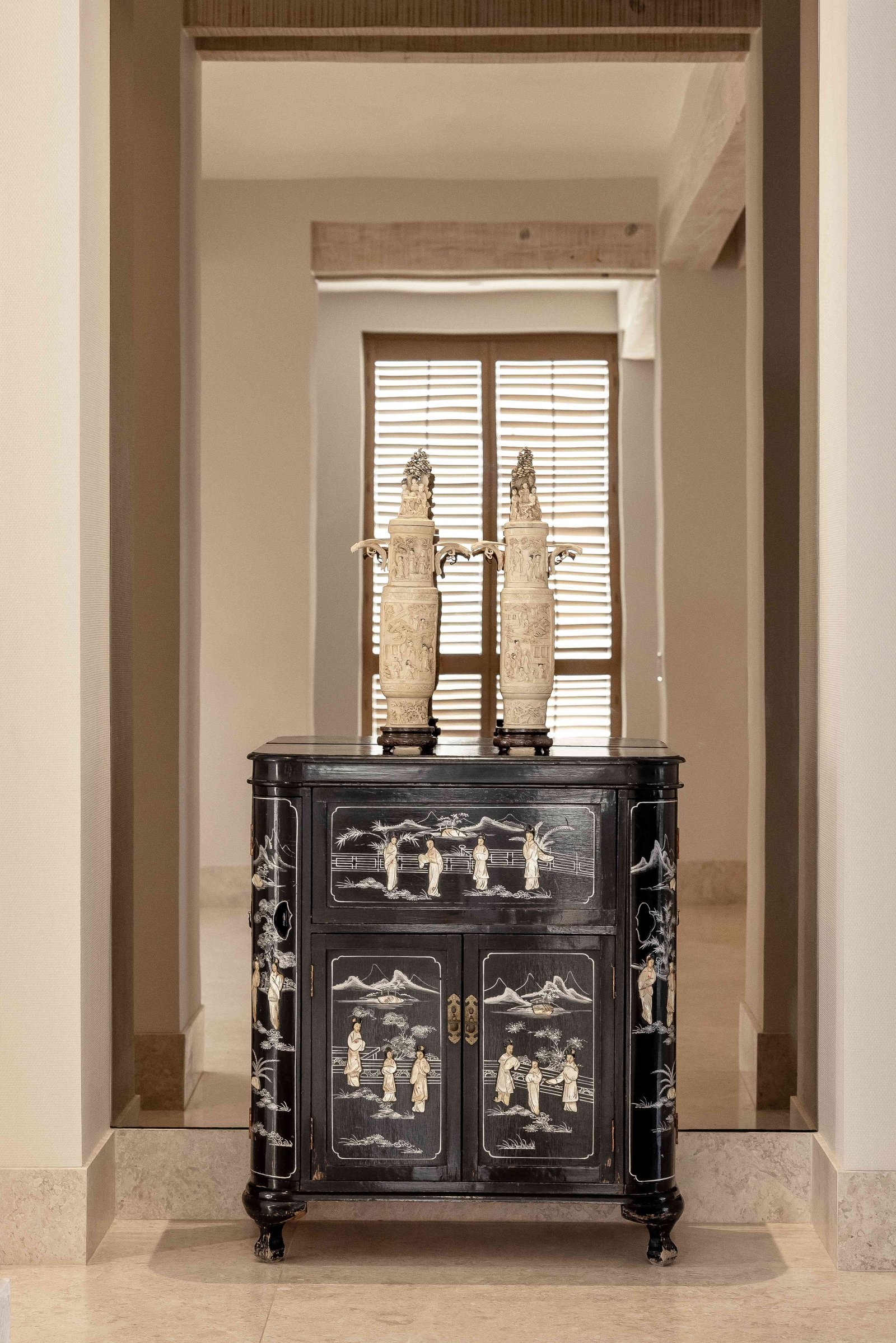 Hallway featuring antique black Chinese lacquered cabinet with decorative vases