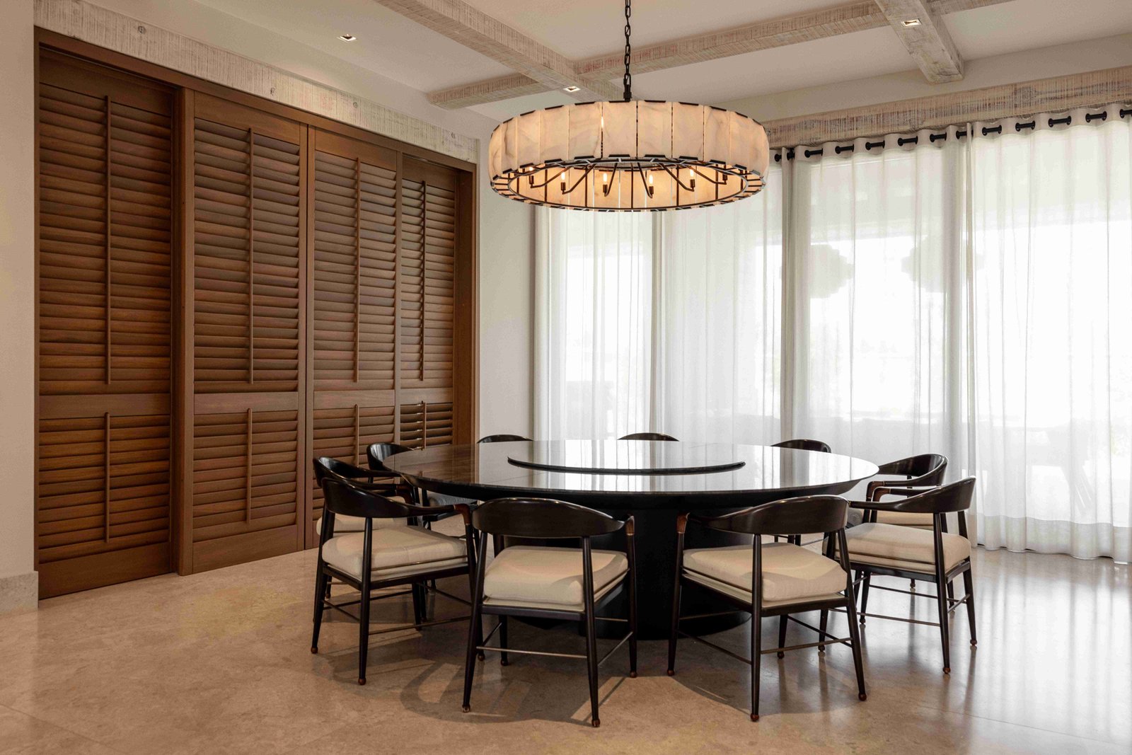 Dining room with round black table and dramatic pendant light