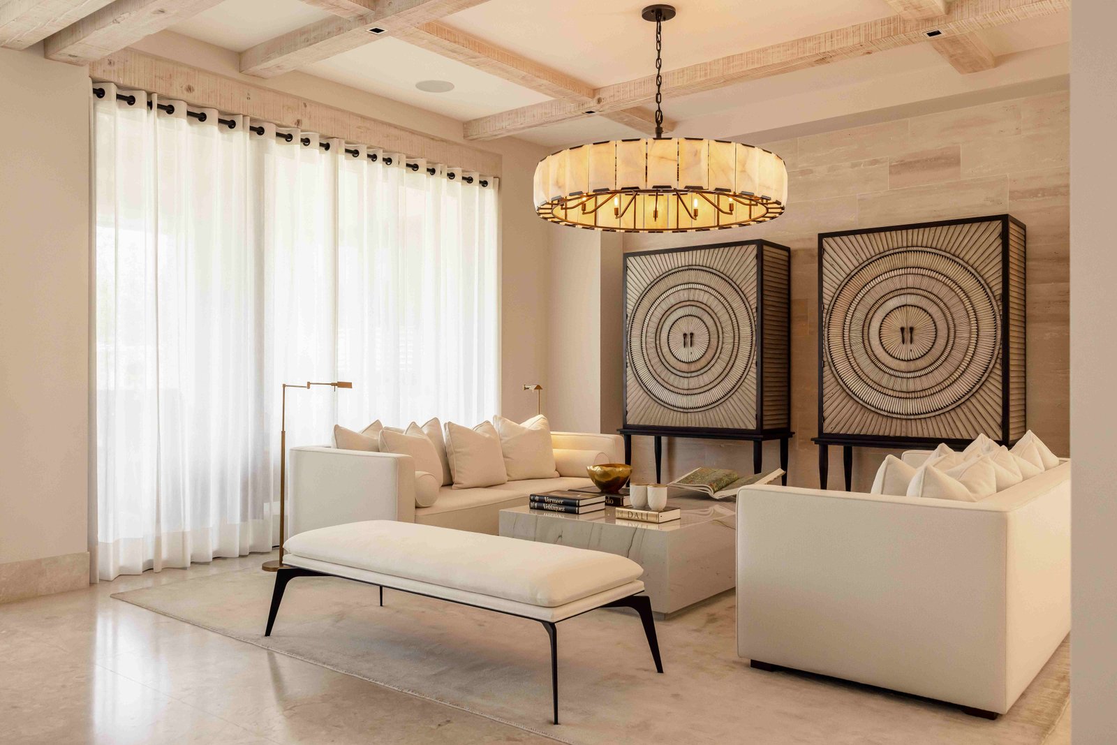 Elegant living room with alabaster chandelier, cream sofas and sheer white curtains